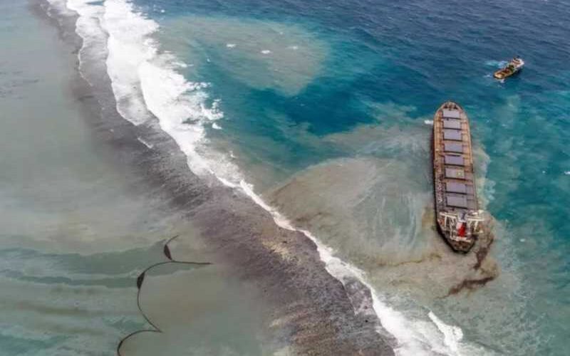 The Wakashio vessel aground on Pointe d'Esny's coral reefs with oil leaking from a crack. A floating oil boom can be seen drifting, a nearby tugboat is ready to intervene when the ship breaks, 10 August 2020. © Ashish K.
