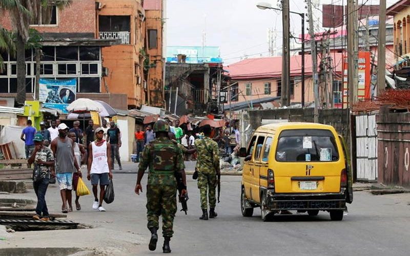 Burned-out buildings and armed gangs in Lagos despite president’s plea