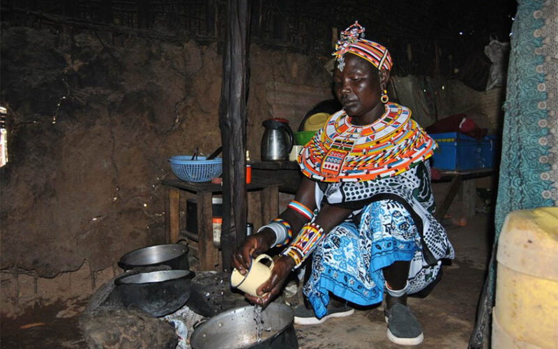 Jane Nolmongen washes a cup in her hut in Umoja village