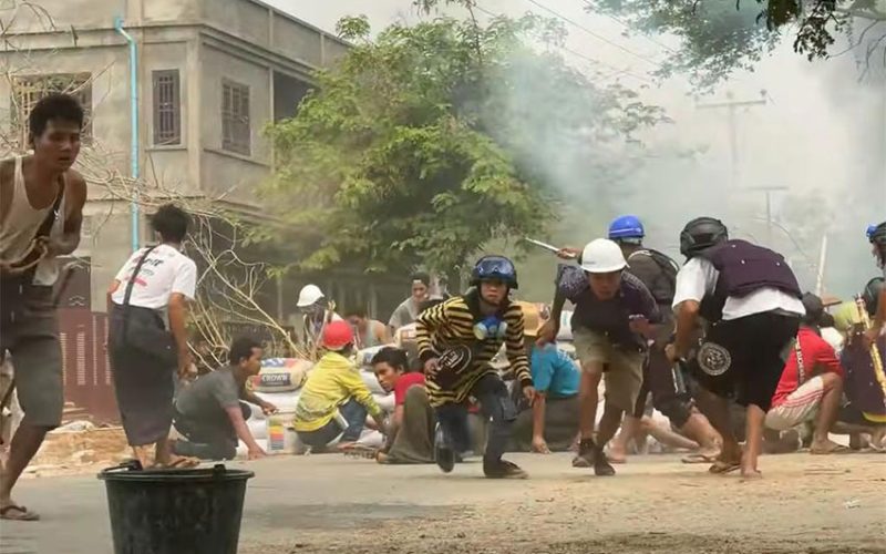 Myanmar protesters take cover during clashes with security forces