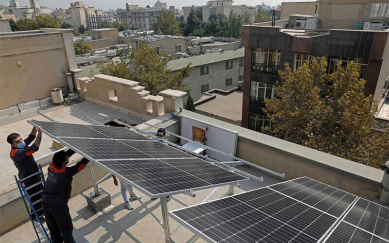 Technicians install solar panels on a residential rooftop
