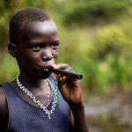 Boy-demonstrates-how-to-use-a-pipe-filter-for-drinking-water