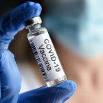 Doctor Holds Bottle With Covid-19 Vaccine In Laboratory. Female