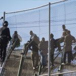 African-migrants-sit-on-top-of-a-border-fence