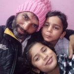 Raju-Usmani-poses-for-a-photo-with-his-two-children