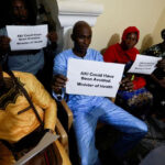 Ebrima-Sagnia-holds-up-a-sign-during-a-news-conference