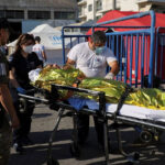 Greece-boat-tragedy_Rescuers-transfer-migrant_ambulance