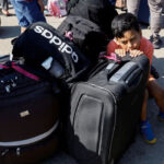 child-rests-on-luggage_Rafah-border-crossing
