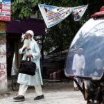 man-walks-past-an-auto-rickshaw-in-Dhubri-district