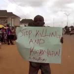 Kaduna_Nigeria_boy holds a sign to protest against kidnappings