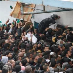 Palestinians gather to receive aid