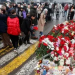 People lay flowers at a makeshift memorial_Moscow