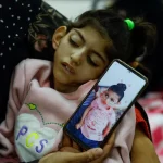 Umm Mesbah Heji holds her malnourished daughter Israa