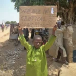 boy holds a sign to protest_Kaduna_Nigeria