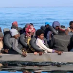 Migrants navigate on a metal boat