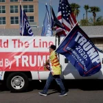 Giuliani charged in Arizona case; Trump an unindicted co-conspirator pro-trump supporter with flag