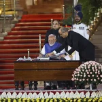 Narendra Modi signs during a swearing-in ceremony