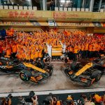 A group overhead picture of McLaren F1 team garage, team principal Andrea Stella, Owner Zac Brown, and drivers Lando Norris and Oscar Piastri celebrating Norris' win in Abu Dhabi and the team's constructors' championship title win.